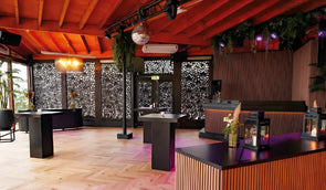Overdekt terras van een beachclub met akoestische wandpanelen in licht walnoot