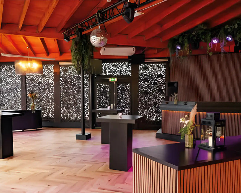 Overdekt terras van een beachclub met akoestische wandpanelen in licht walnoot