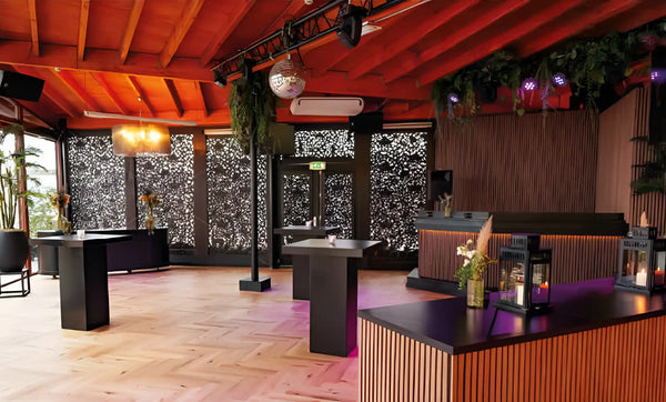 Overdekt terras van een beachclub met akoestische wandpanelen in licht walnoot