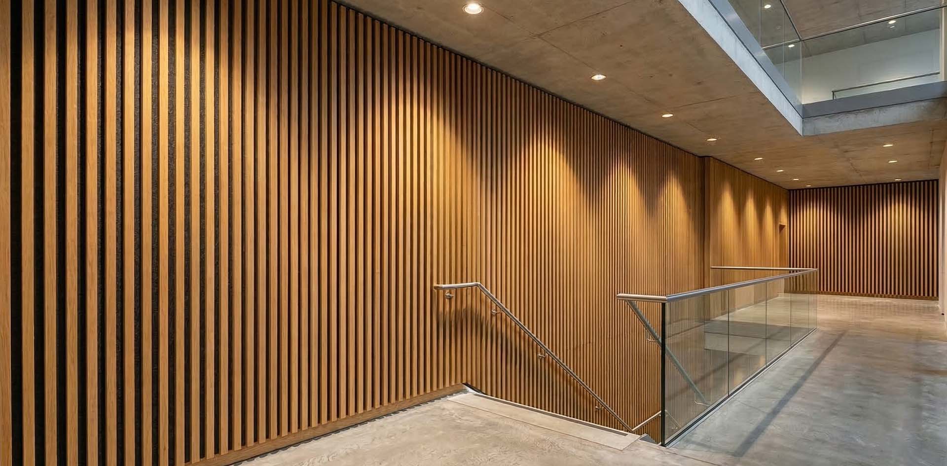Brandwerende akoestische wandpanelen van eiken fineer met 28mm houten latten in commercieel trappenhuis — B-s1,d0 gecertificeerd door SGS
