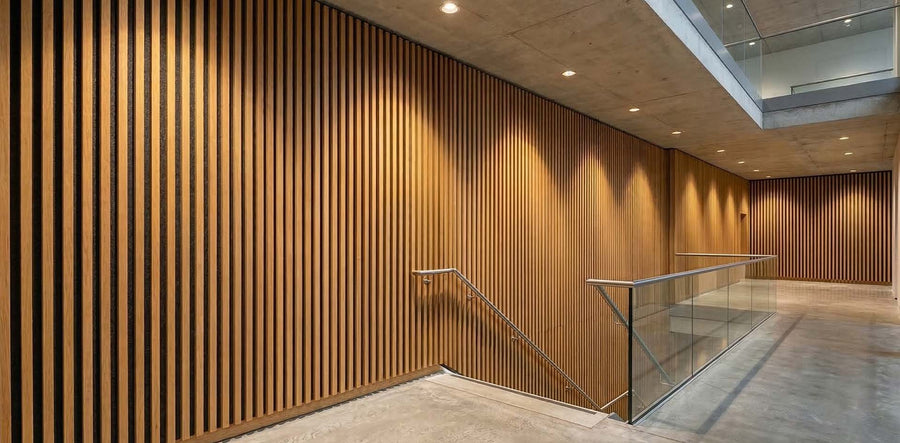 Brandwerende akoestische wandpanelen van eiken fineer met 28mm houten latten in commercieel trappenhuis — B-s1,d0 gecertificeerd door SGS