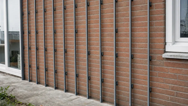 Aluminium regelwerk voor gevelbekleding op een bakstenen muur, met stelblokjes en open ventilatiespouw
