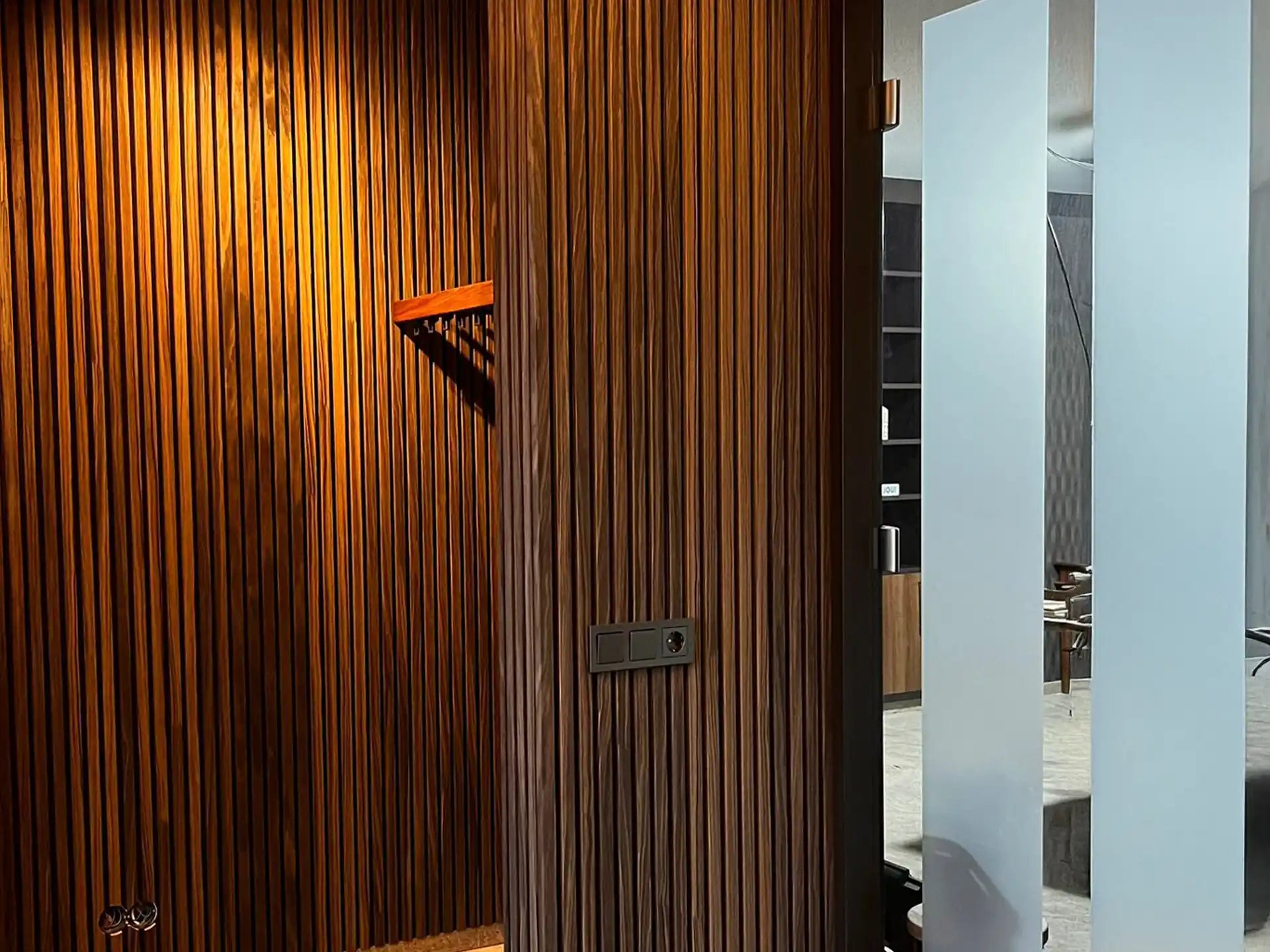 Akoestische wandpanelen in gerookt eiken geplaatst in een moderne entree met warme sfeer