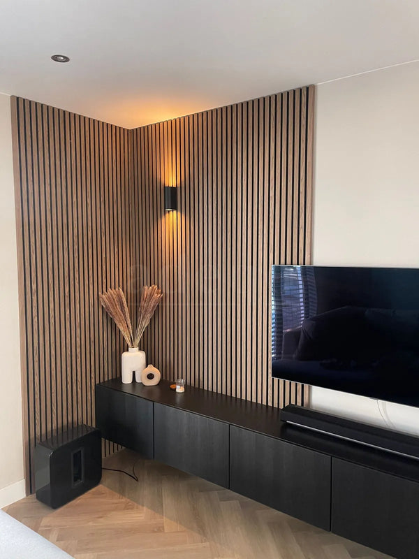Klassiek walnoot akoestische wandpanelen rond een TV-wand in een moderne woonkamer met sfeerverlichting