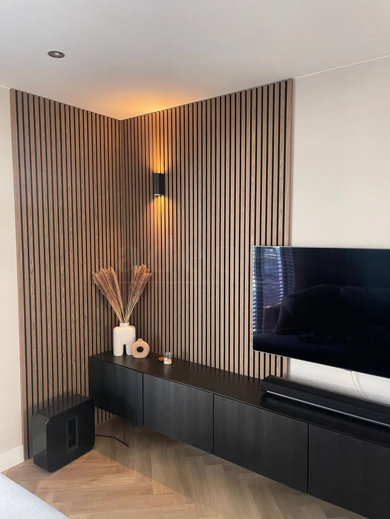 Klassiek walnoot akoestische wandpanelen rond een TV-wand in een moderne woonkamer met sfeerverlichting